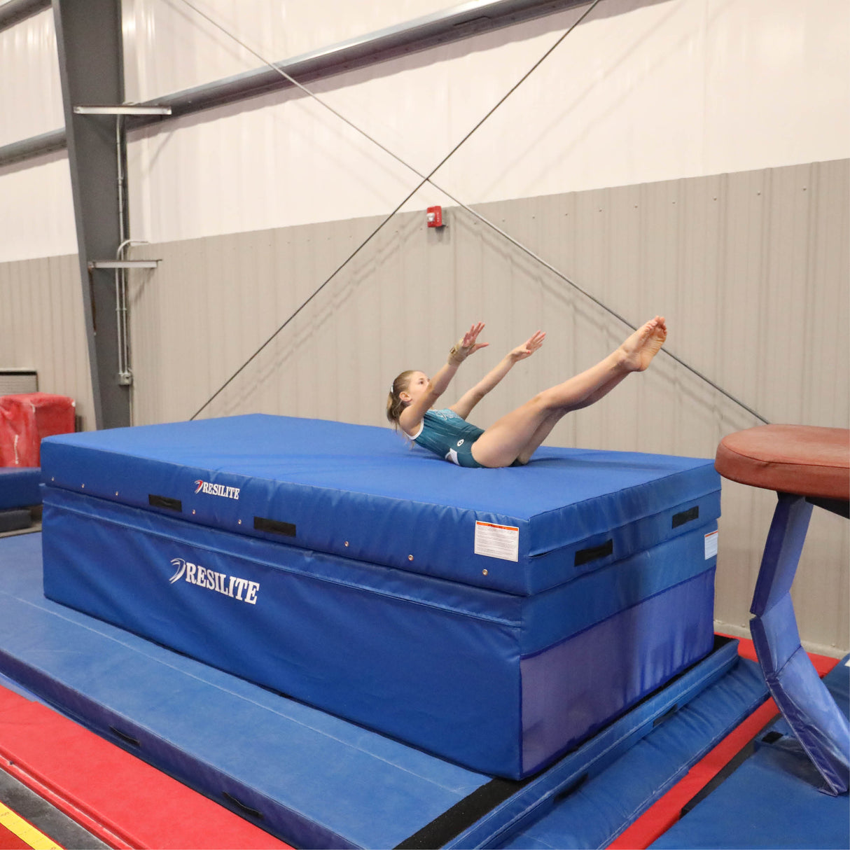 gymnast practicing vault landing on foam crash mat training surface