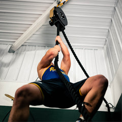 athlete climbing Infiniti battle rope for strength and conditioning workout