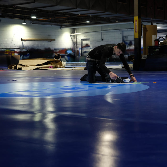 Resilite Mat Craftsman hand paints the NCAA logo on to a Resilite Classic Mat