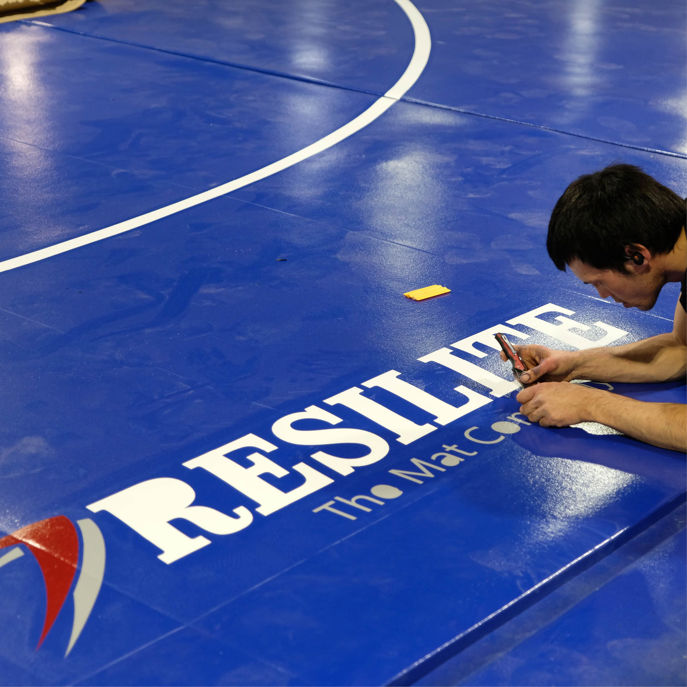 A Resilite Mat Craftsman carefully prepares a Classic Wrestling Mat
