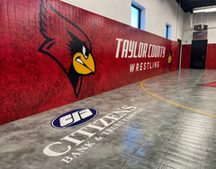 Wrestling facility interior with Taylor County Wrestling logo on a red wall - Resilite