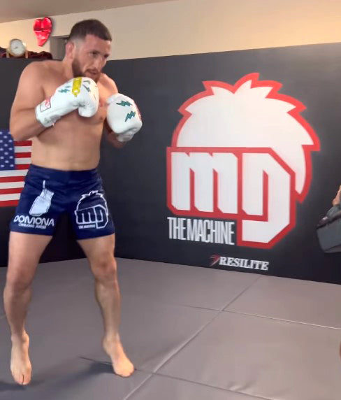 UFC fighter training on a Resilite Hybrid wrestling mat with Resilite Flex3 wall padding for impact protection